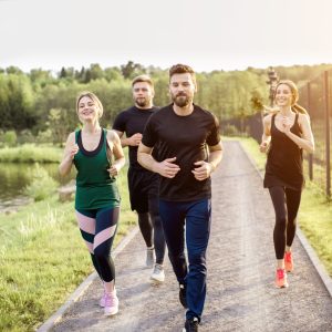 Group of friends jogging during the morning exercise in the park near the lake