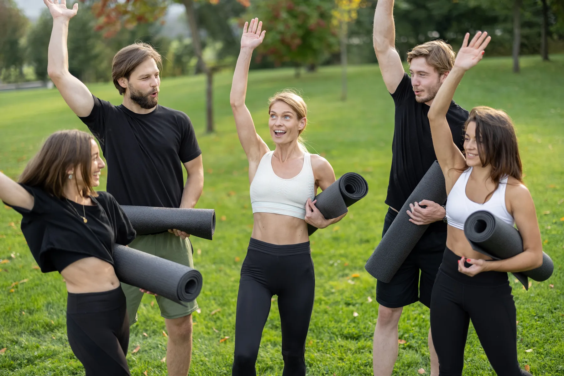 Een groep volgt buiten een rustige training op sportmatten